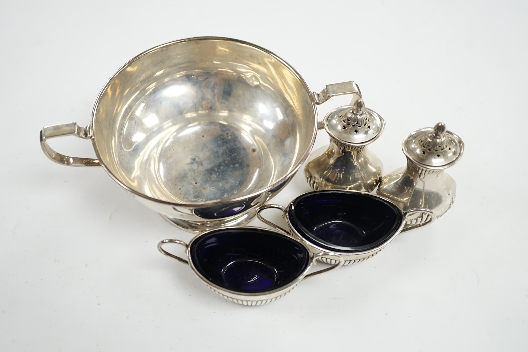 A George V silver two handled bowl and two pairs of early 20th century silver condiments. Condition - poor to fair